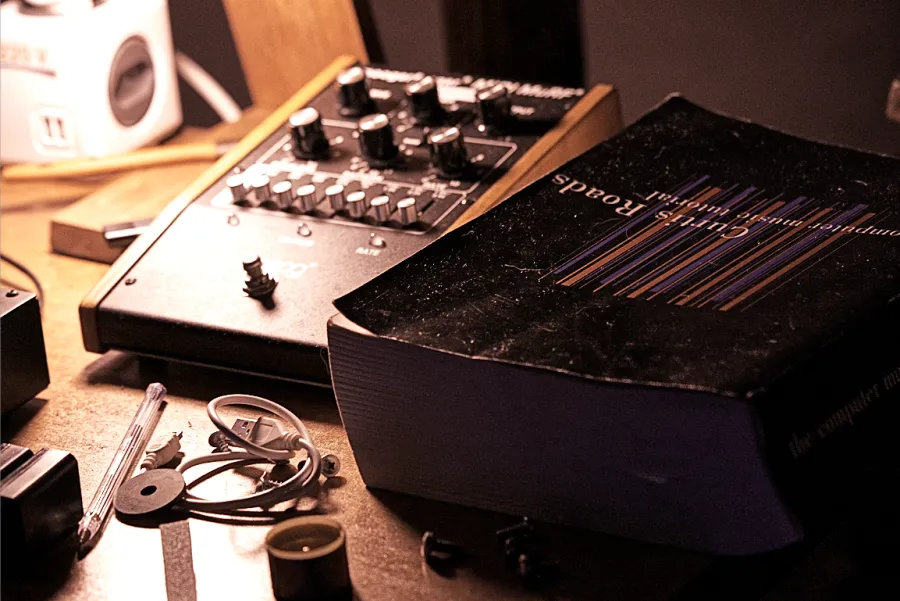 Moog synthesizer and Curtis Roads book on a studio desk